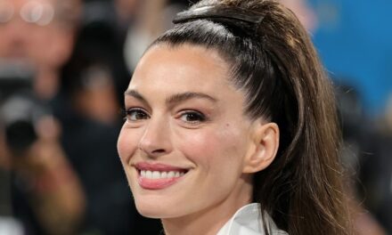 Anne Hathaway prend une chute dans des talons cloutés et une chemise tartan transparente