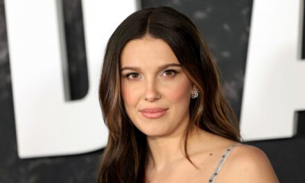 Millie Bobby Brown est un «  automne rouge cerise &lsquo;en mini short confortable et un sweat-shirt assorti