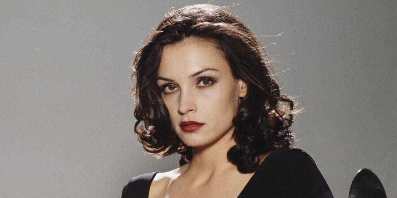 Bond girl, 61 ans, ressemble à une déesse dans une robe vert écume audacieuse et décolletée avec une jupe en tulle transparent