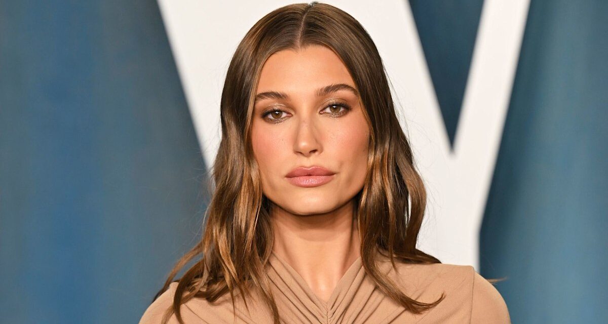 Hailey Bieber porte des collants transparents, des bottes hauteur genou et un double tweed pour atterrir à Londres