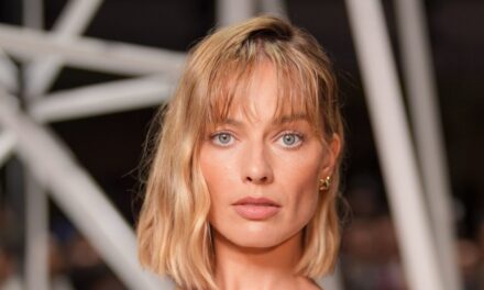 Margot Robbie arrive à PFW dans un haut transparent et un carré blond fraîchement coupé